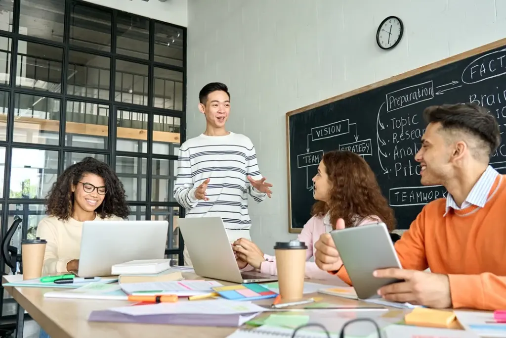 Team collaboration in a modern office setting, with diverse professionals discussing custom AI solutions at a table, featuring a laptop displaying the Lyfe AI logo.