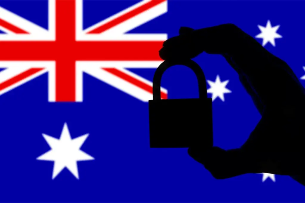 Hand holding a padlock in front of the Australian flag, symbolising data security and compliance with Australian regulations.